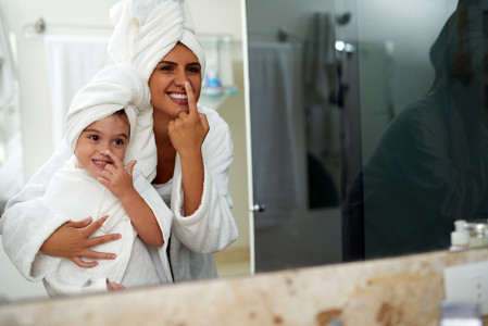 Mother and daughter towel-drying their hair