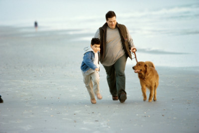 father, son, dog on beach