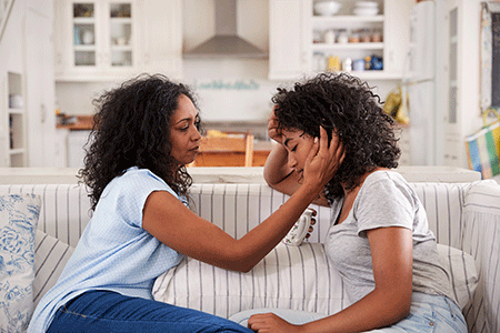 Mother comforting daughter who has painful hidradenitis suppurativa