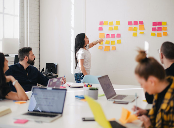 Woman leading meeting at whiteboard