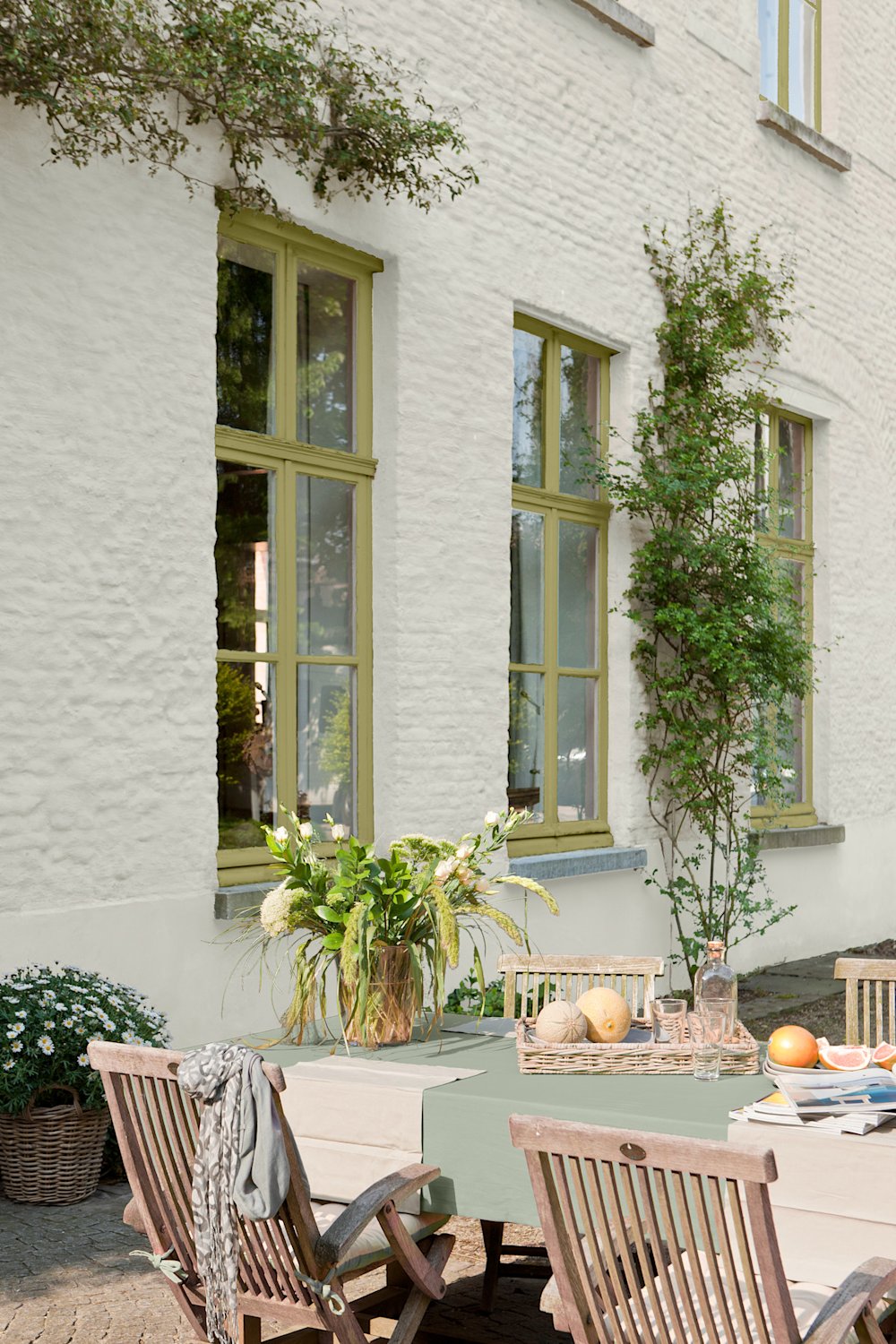 witte buitengevel met groene ramen