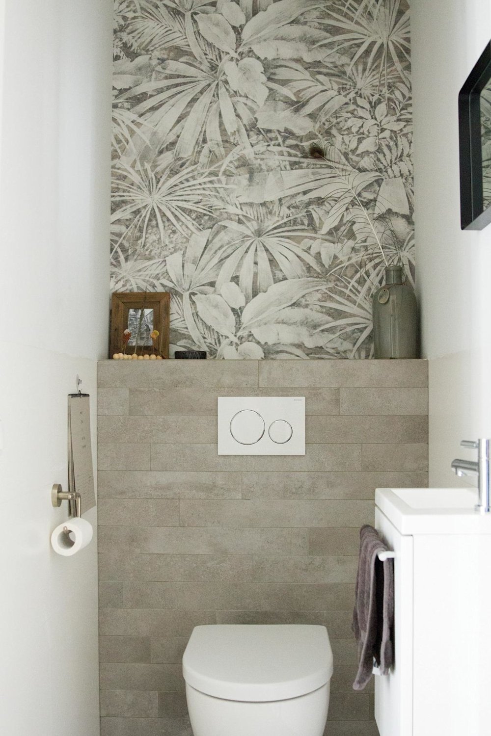 Inspiratiebeeld colora - toilet met accentmuur in behang met bladeren print - witte muren en grijze stenen
