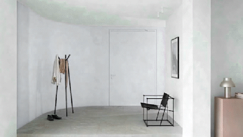 Minimalistische ingang met een kapstok, zwarte stoel, ingelijste muurkunst en een kastje met een lamp tegen witte muren.