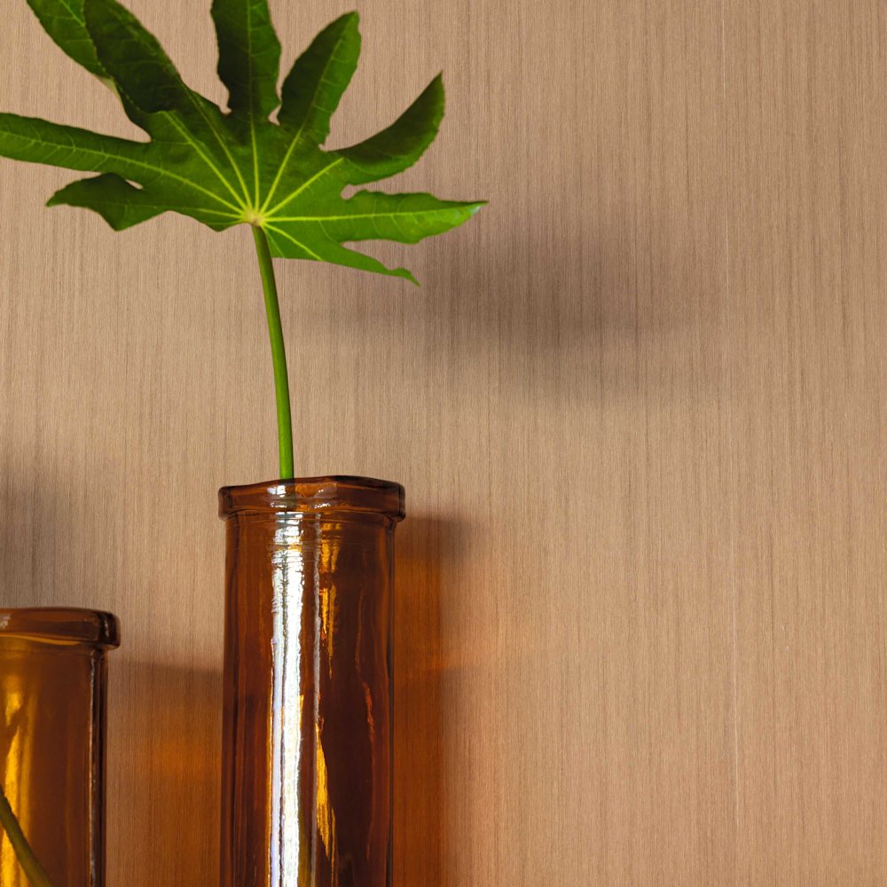 behang - woonkamer - Caselio - Woodline - WOD106802020 - geel - bruin - houten wand in warme tint, amberkleurige glazen vazen, groene bladertak