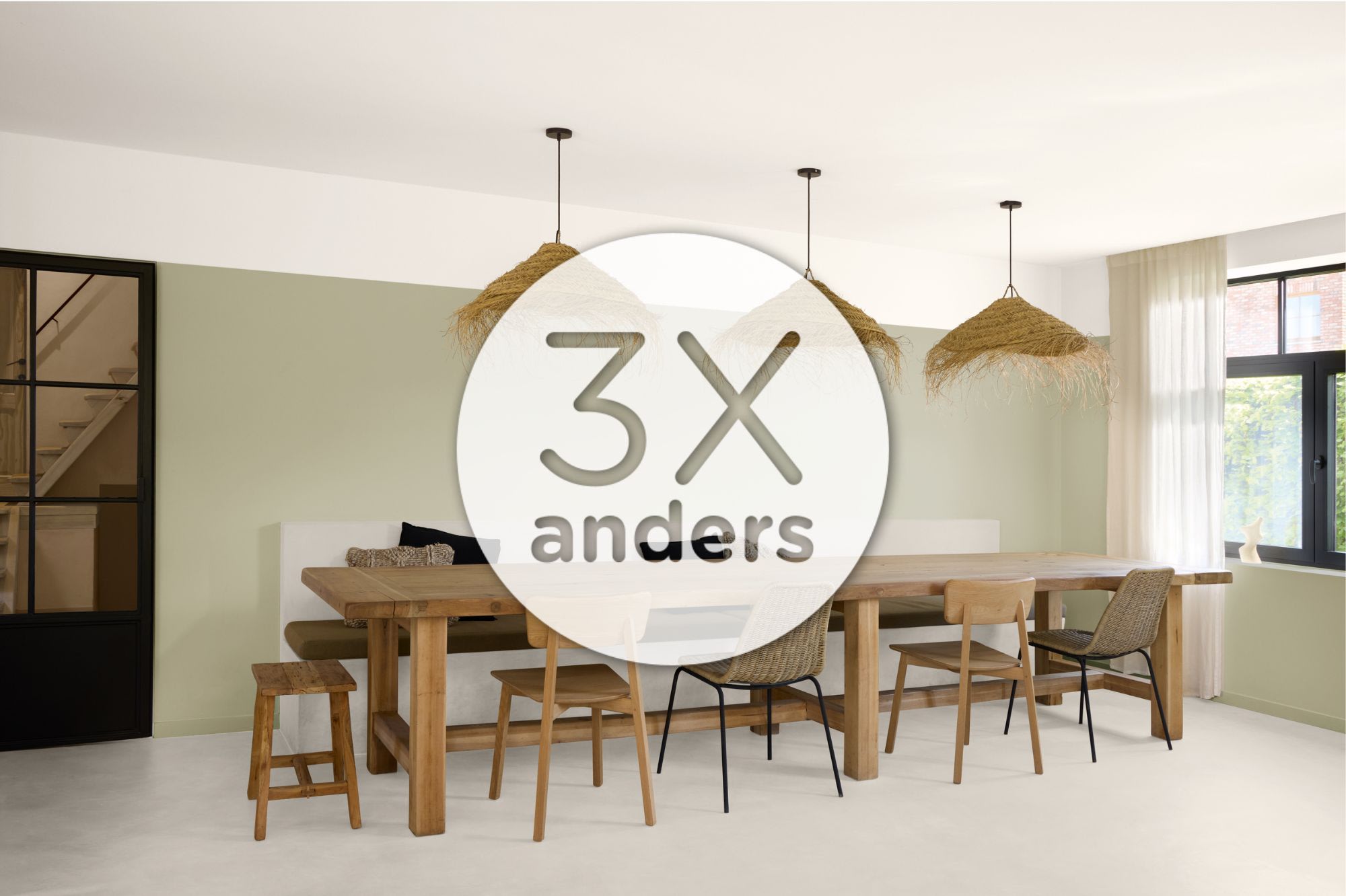 Moderne eetkamer met houten tafel, gemêleerde stoelen, geweven hanglampen, lichtgroene accentmuur en groot rond oplegblad met "3x anders" in het midden.