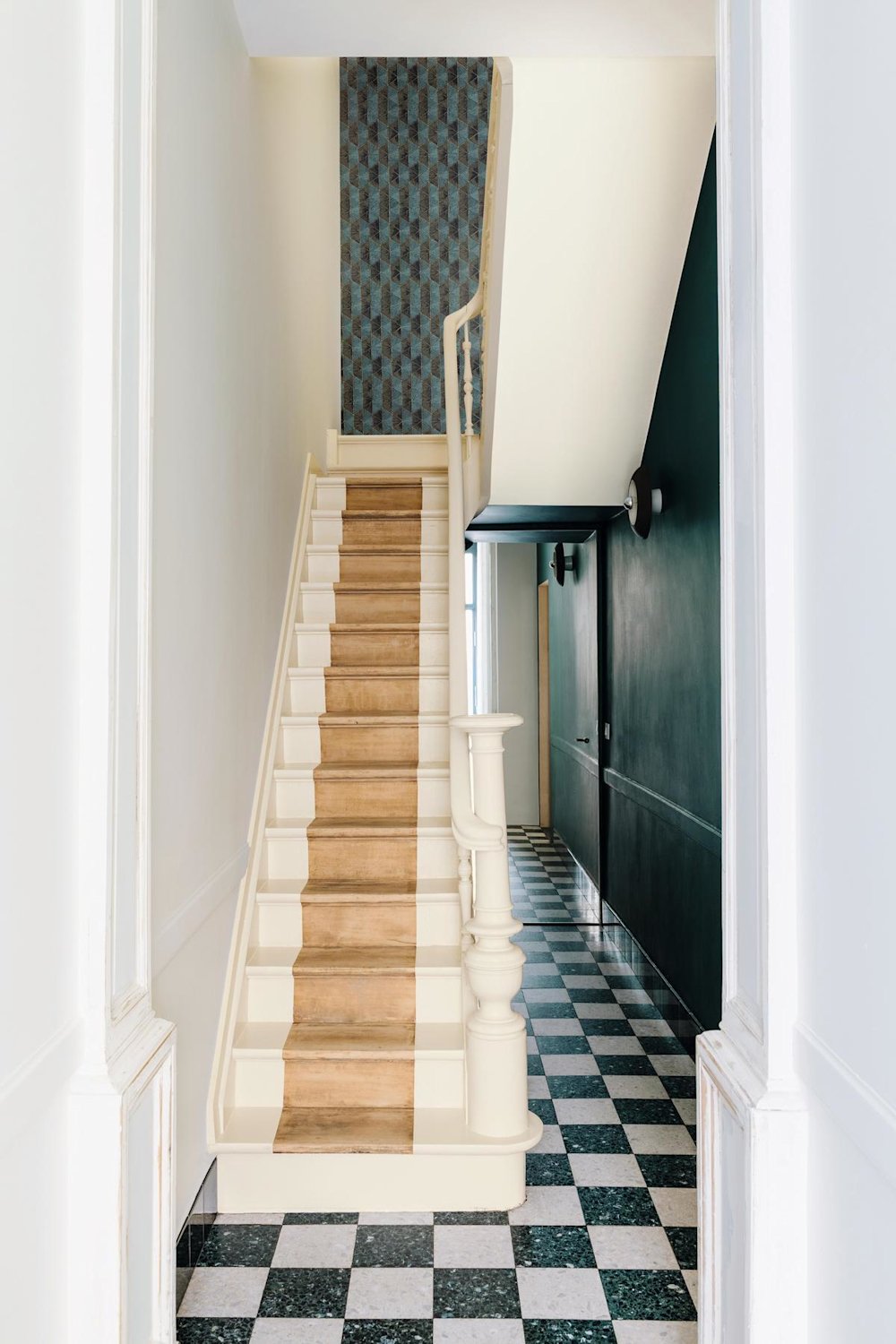 Inspiratiebeeld colora - witte houten trap met donkergroene accentmuur Masureel behang in hal - coloramagazine SS2021