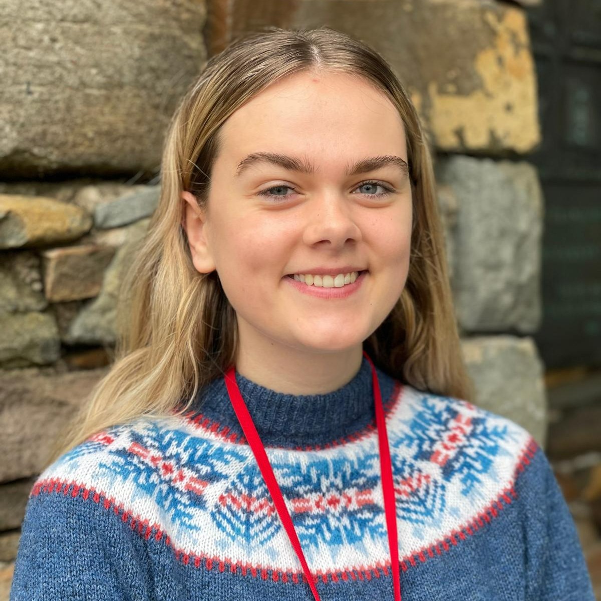 Headshot of blonde girl in blue patterned jumper.