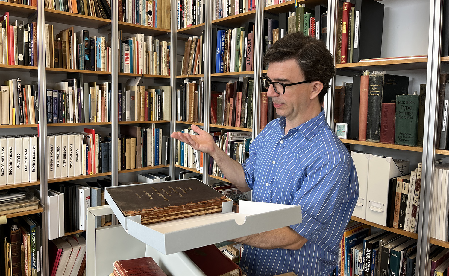 Tobias showing off a type specimen book from Farmer, Little & Company; 1885