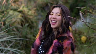 Young asian woman wearing bright colored clothing and yellow eyeshadow.