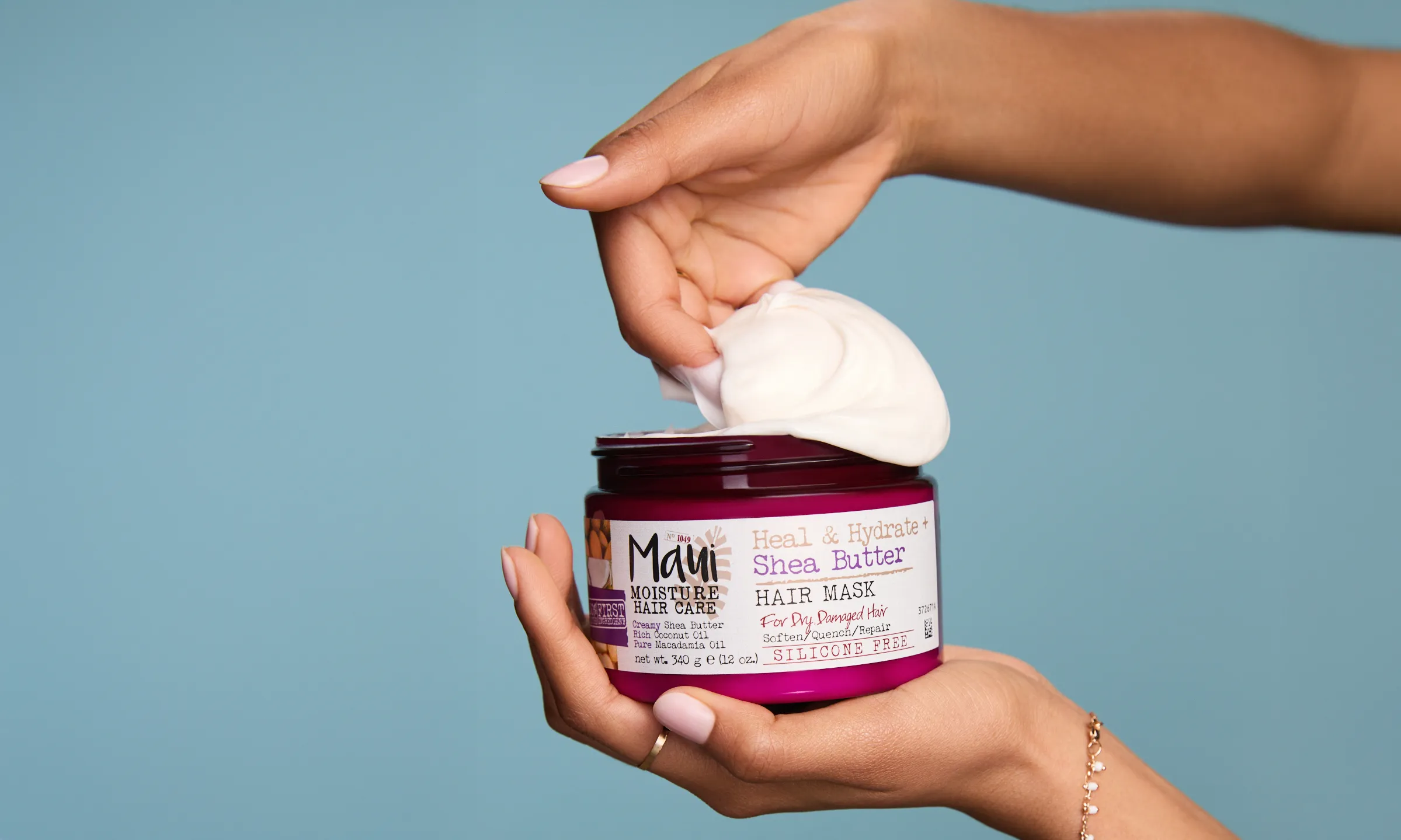 Woman putting Maui Moisture Shea Butter Hair Mask into her hands