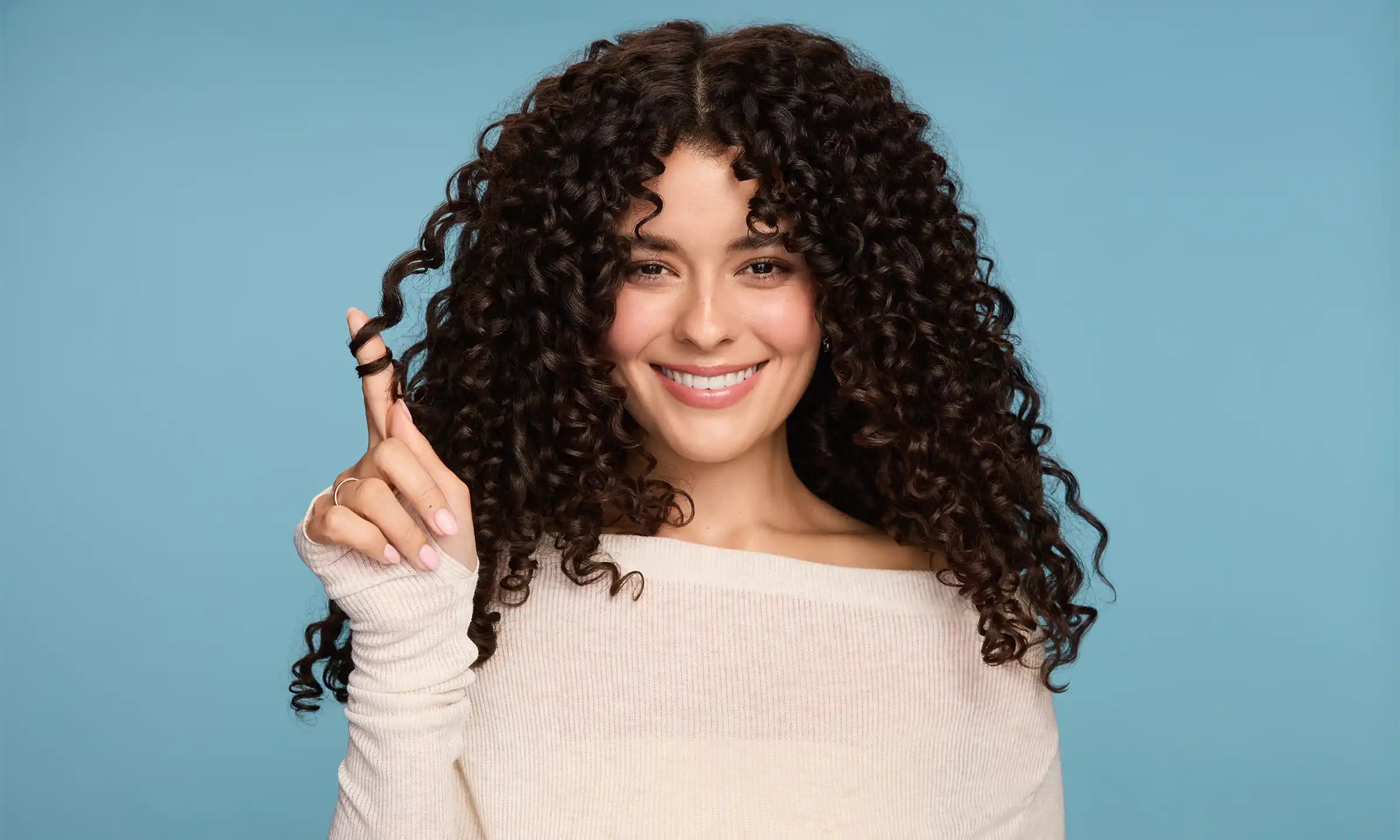 Woman with healthy curls touching her hair
