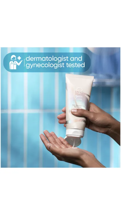سيدة تضع مقشرًا لتنعيم البشرة من Satin Care على يدها أثناء الاستحمام