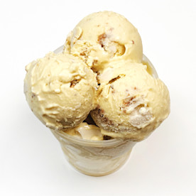 scoops of butterscotch colored ice cream in a semitransparent cup