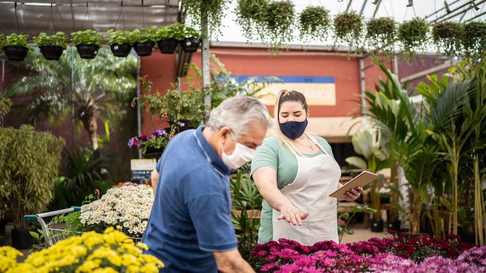 Empleada enseñado a un cliente dónde está el producto