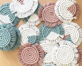an assortment of woven spiral coasters in white, teal, and blush tones