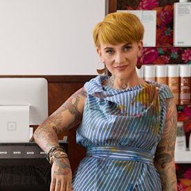 Portrait of a female hair stylist standing at a counter in a hair salon