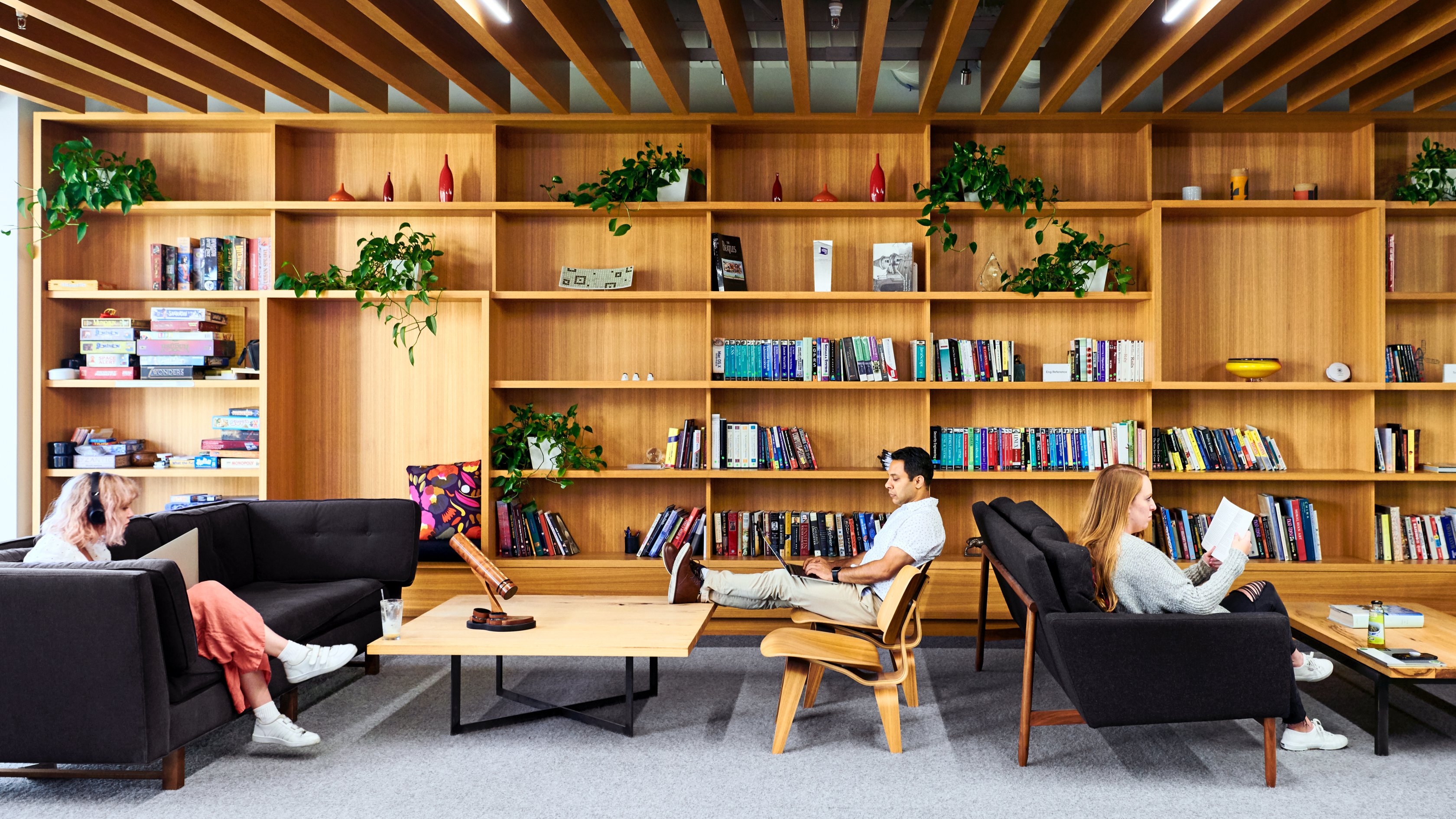 photo of people working with bookshelves in the background