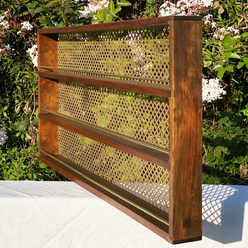 a dark wooden and brass three-tier spice rack