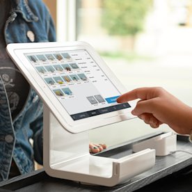 Photo of someone checking out a customer in a retail store using Square Stand for contactless and chip