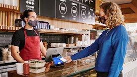 Empleado atendiendo y cobrando a un cliente.