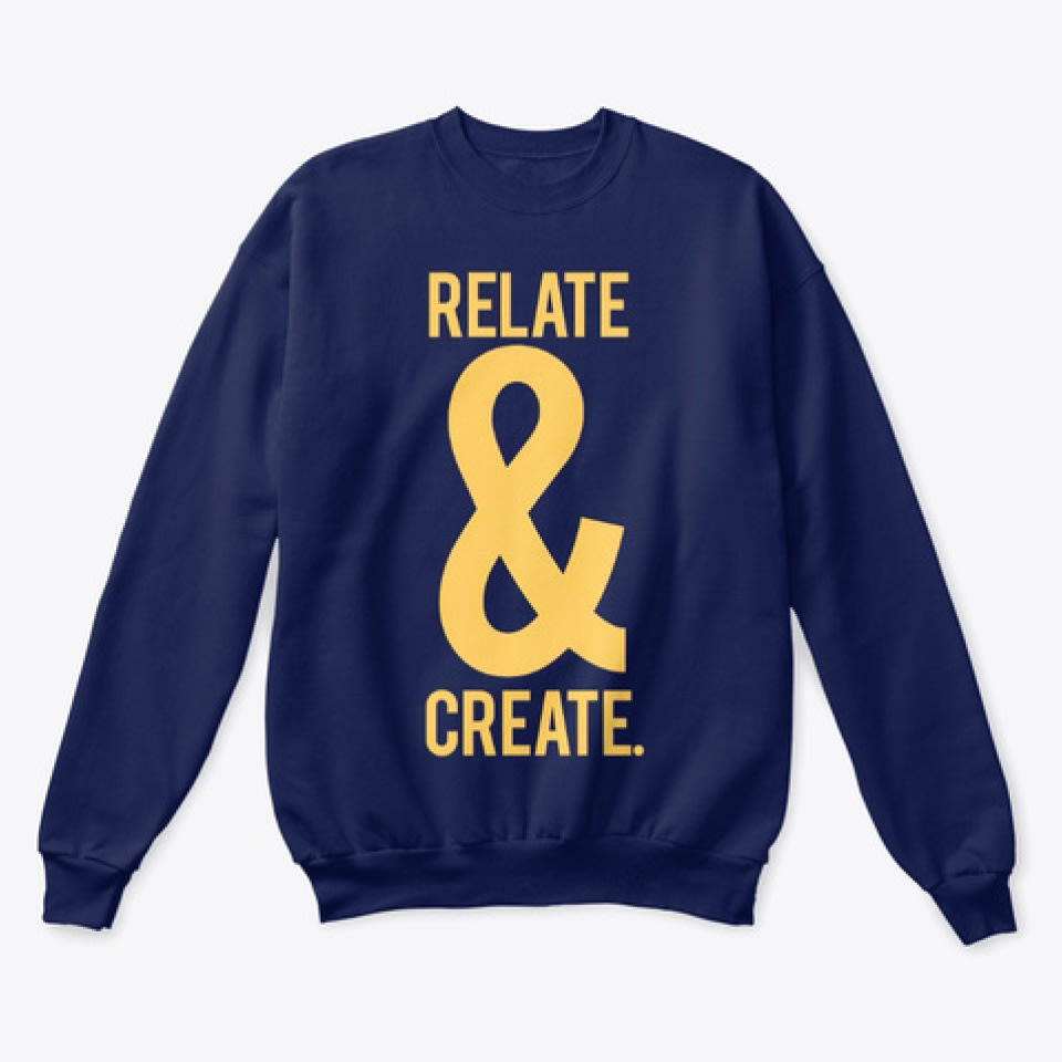 a blue crew-neck sweater with yellow writing that reads RELATE & CREATE.