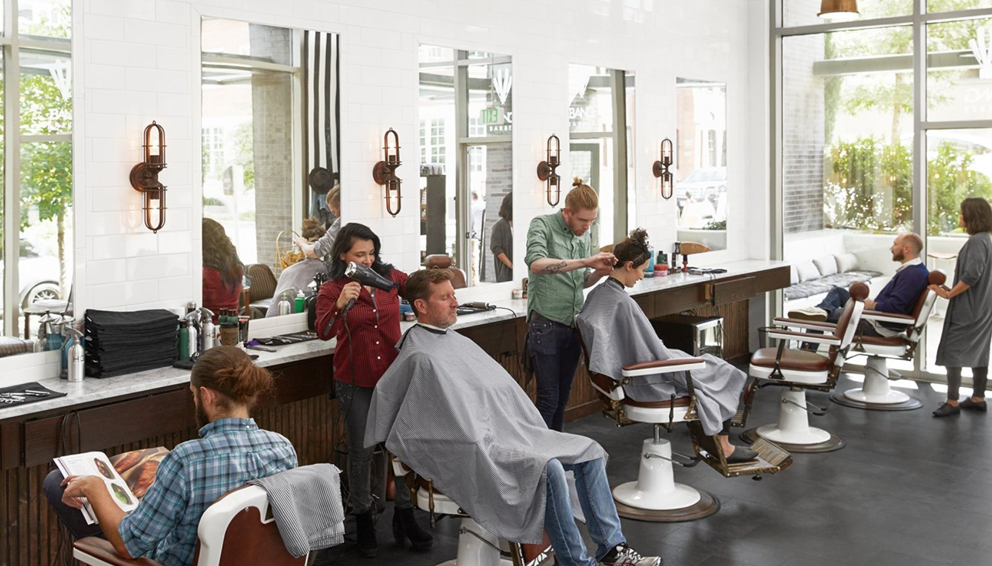 Empleados cortando el pelo a clientes en una peluquería