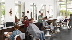 Empleados cortando el pelo a clientes en una peluquería