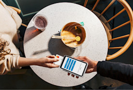 A woman inserting a mastercard into the Square Terminal hardware to pay for her food.