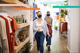 Two shoppers in a retail store wearing masks, having an in-store shopping experience.