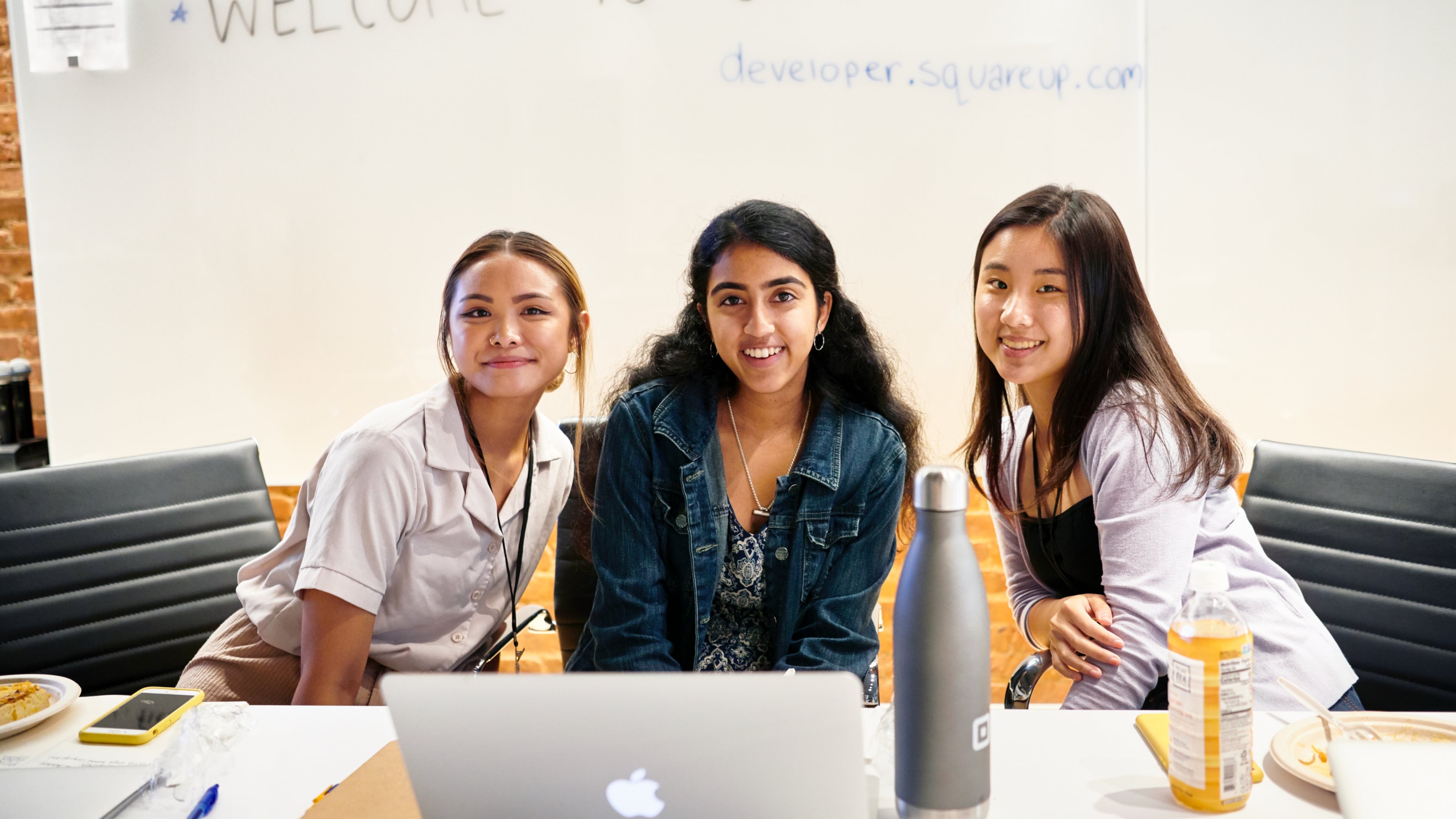 photo of 3 people with a whiteboard behind them