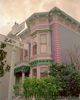 a photo of a colorful house with white street signs in the foreground