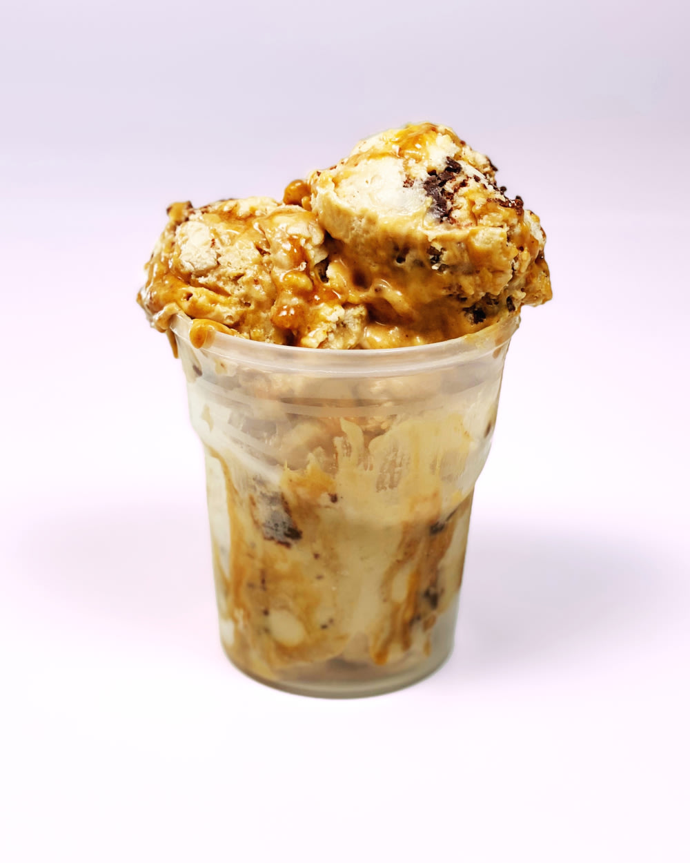 Ice cream in a plastic cup with a golden drizzle