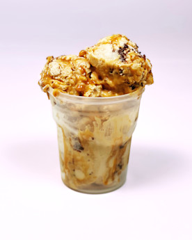 Ice cream in a plastic cup with a golden drizzle
