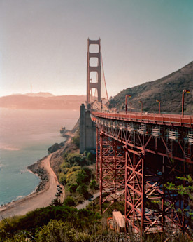 a photo of the Golden Gate Bridge with the shoreline visible on the left hand side