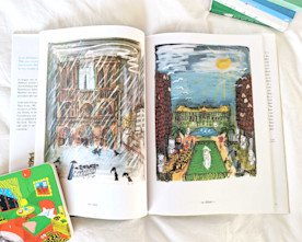 an open book on white linens shows two full-page illustrations