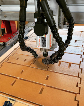 a CNC machine cutting shapes out of plywood