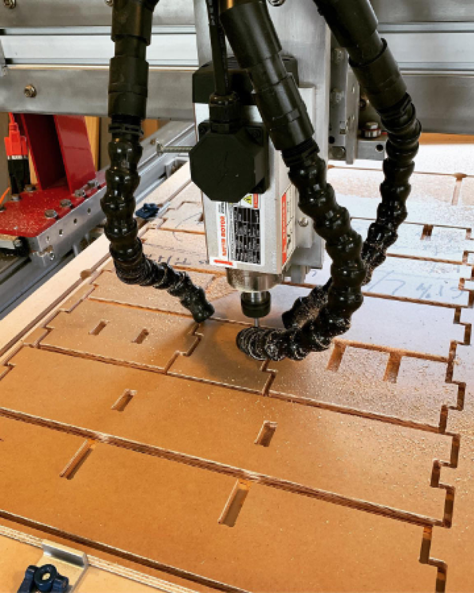 a CNC machine cutting shapes out of plywood