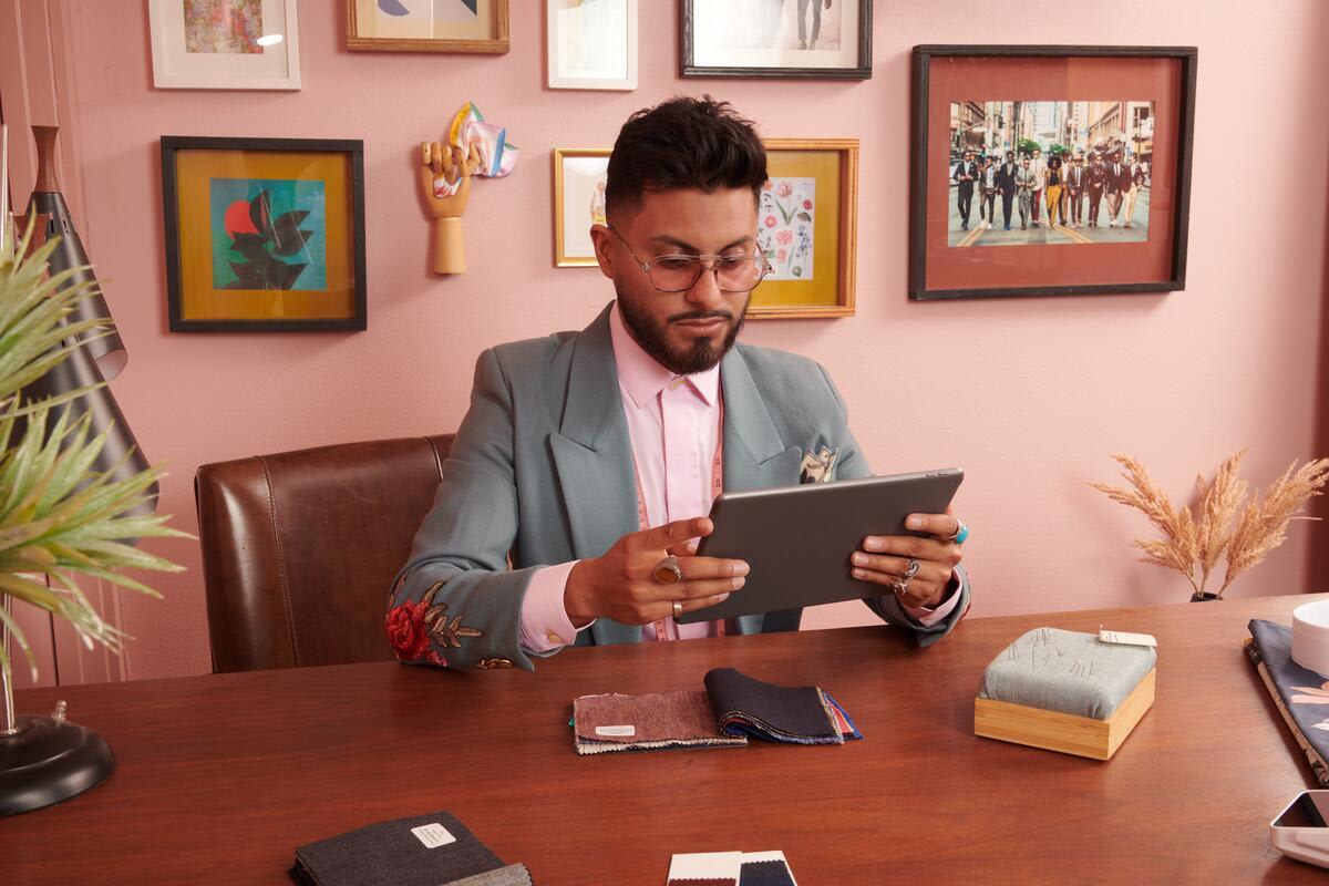 Un homme assis à un bureau avec un ipad à la main
A man sitting at a desk with an ipad in his hand