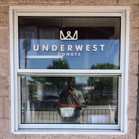 a photo of a window with a logo that reads UNDERWEST DONUTS