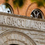 The exterior of a stone and brick building on Gonzaga University's campus is seen behind orange autumn leaves
