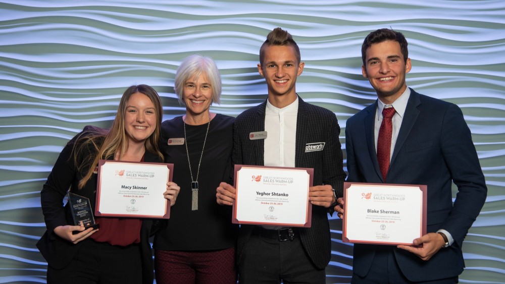 Four students from the University of South Carolina pose and hold their winning certificate from the Darla Moore School of Business Annual Sales Competition