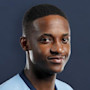 Nkusuwila, an international student from Zambia at UIC, wears his UIC Flames soccer jersey and smiles at the camera
