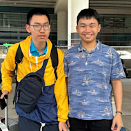 Hung and Hieu, two brothers from Vietnam studying at the University of Utah, stand at the airport with their luggage and smile for the camera