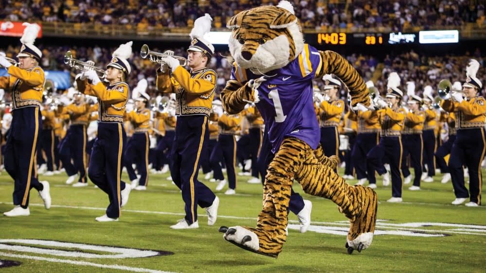 Mike the Tiger, the mascot of LSU, runs out on the football field with the LSU Marching Band