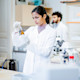 A female international student in a Pharm D program at a US university works in a lab on campus for an assignment for her pharmacist courses.