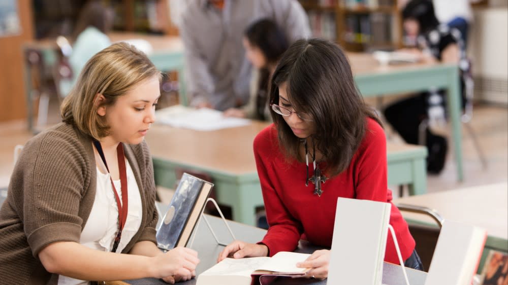 A female international student from Asia sits with a credential evaluation expert and goes over paperwork