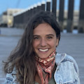 Taylor Falcone, Shorelight’s Senior Coordinator, Program Marketing, stands in front of a harbor and smiles for the camera.