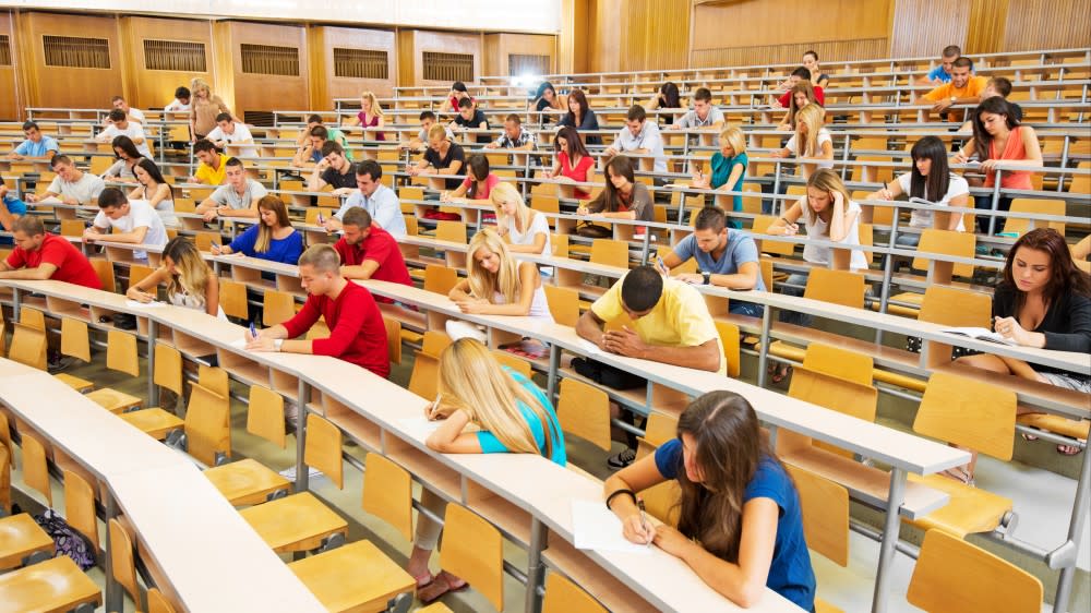 ACT or SAT? After learning what is the act test and thinking about should i take the act or sat, students sit in rows in a multi-level lecture hall and take their standardized test after deciding whether to take the act vs sat.