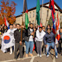 A group of international students at the University of Wisconsin-Platteville stand together on campus holding flags from their home countries