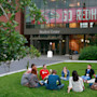A group of international students at Seattle University sit outside on campus and discuss an assignment